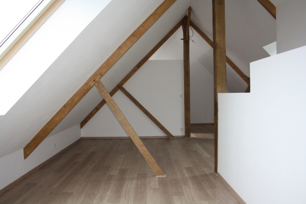 agencement de combles avec parquet et poutres apparentes